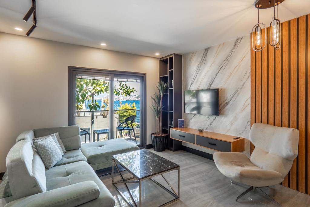 a living room with a couch and a tv at Yalikavak Residence Apartment in Bodrum City