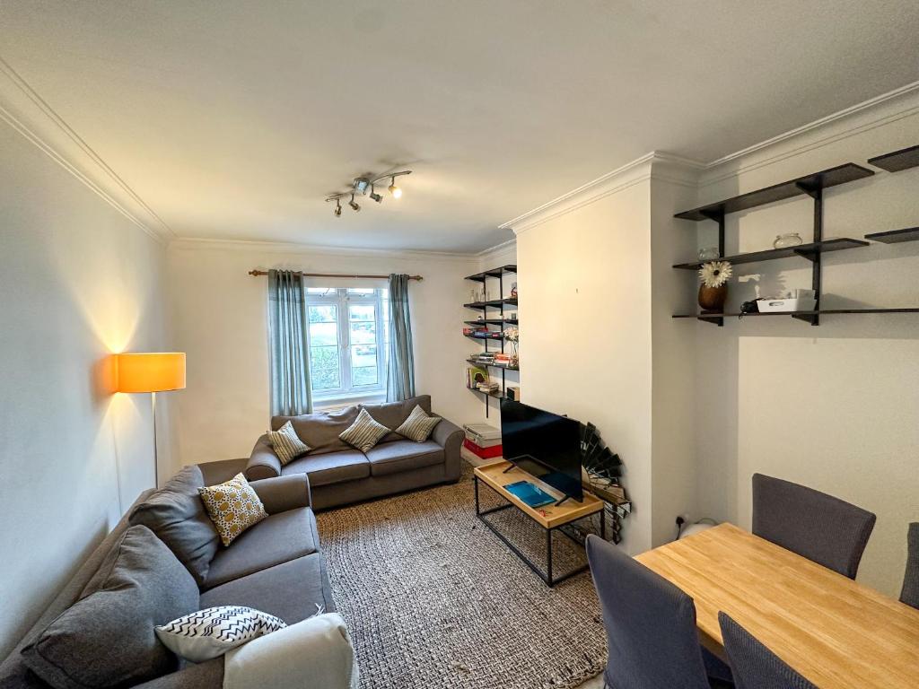 a living room with a couch and a table at 2 Bed Flat - 5 min walk from Brent Cross Station in Hendon