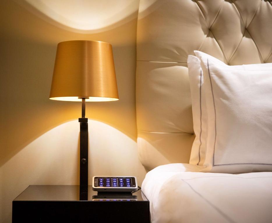 a lamp sitting on a table next to a bed at Park Plaza London Riverbank in London