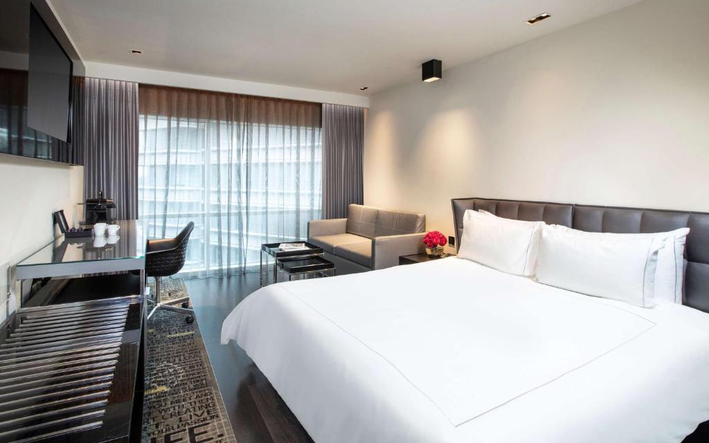 a hotel room with a large white bed and a chair at Park Plaza London Riverbank in London