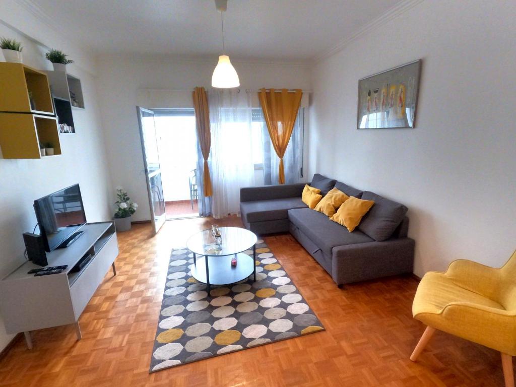een woonkamer met een bank en een tafel bij Sintra T2 Rinchoa in Sintra