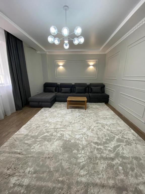 ein Wohnzimmer mit einem Sofa und einem Tisch in der Unterkunft Двухкомнатные бизнес апартаменты в ЖК Томирис in Atyrau