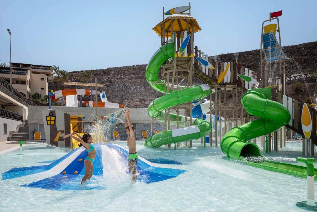 duas pessoas a brincar num escorrega aquático num parque aquático em Occidental Jandía Mar em Morro del Jable