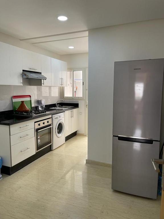 a kitchen with a stainless steel refrigerator and a dishwasher at Tarek tours in Inezgane
