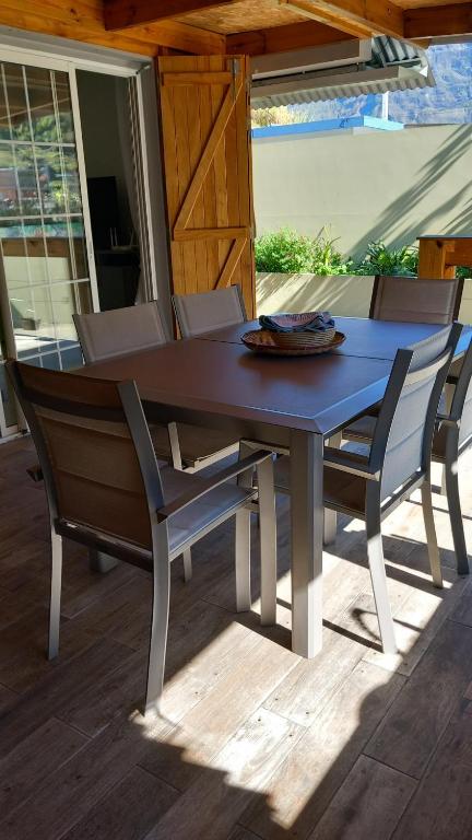 une table bleue et des chaises sur une terrasse dans l'établissement La Kaz'ida, à Cilaos
