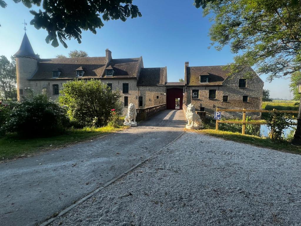 uma casa velha com uma estrada em frente em Château le Withof em Bourbourg