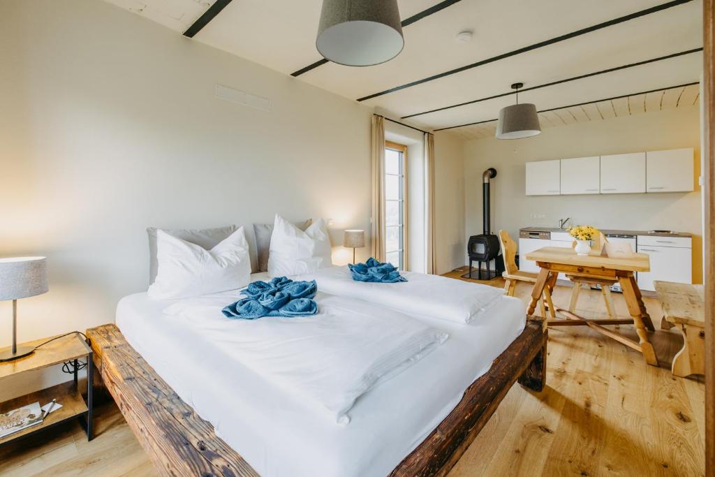 a bedroom with a large white bed with blue pillows at Käferberghof 