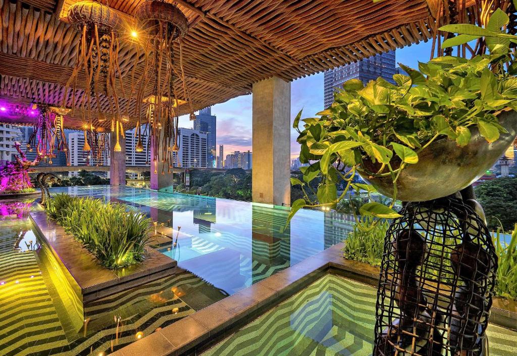 a swimming pool with a potted plant on a building at The Orient Jakarta, a Royal Hideaway Hotel in Jakarta