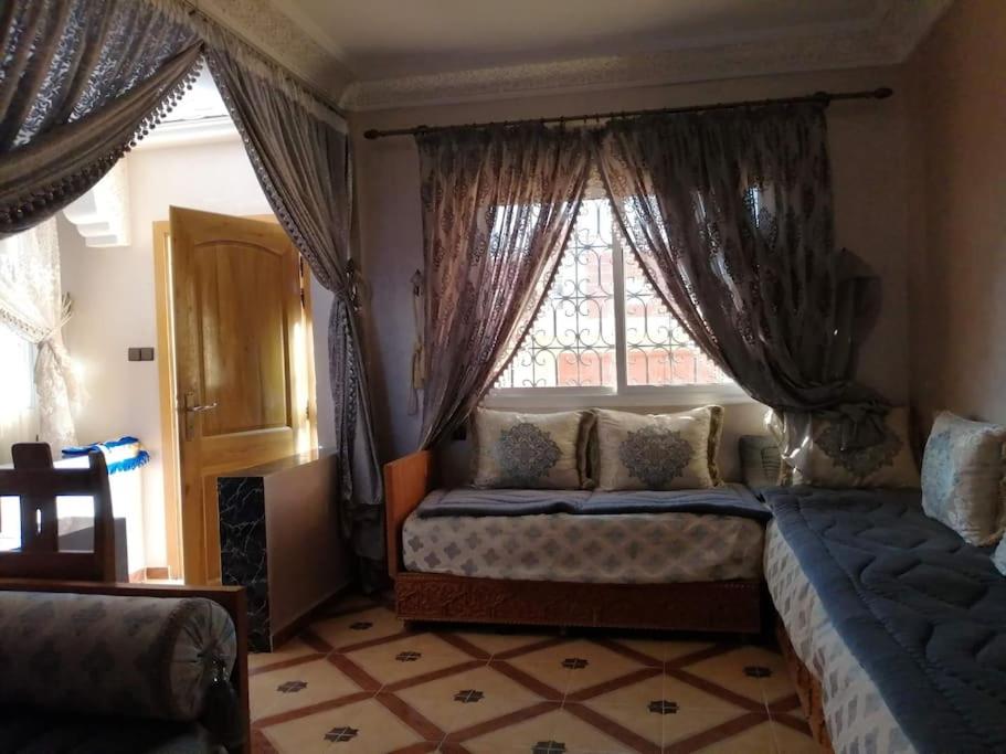 a bedroom with a bed and a window with curtains at Imssouane cathédrale in Imsouane