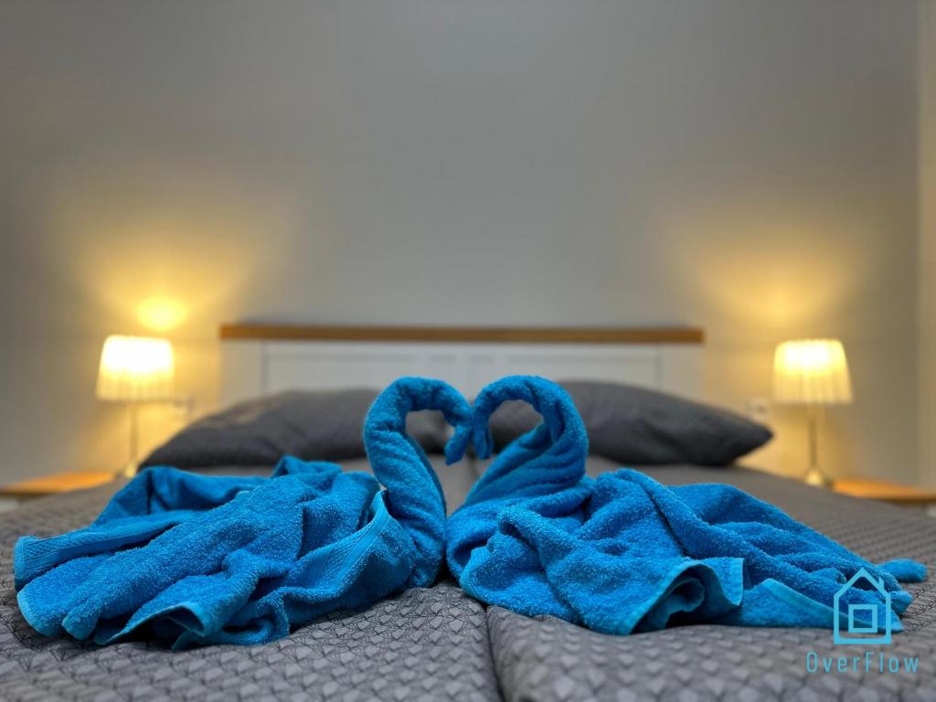 two towels in the shape of a heart on a bed at Anchor Apartment in Gdańsk