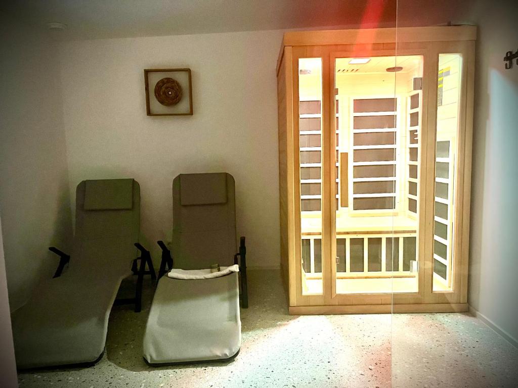 Habitación con 2 sillas y puerta corredera de cristal en Chic&cozy with Sauna, en Liubliana