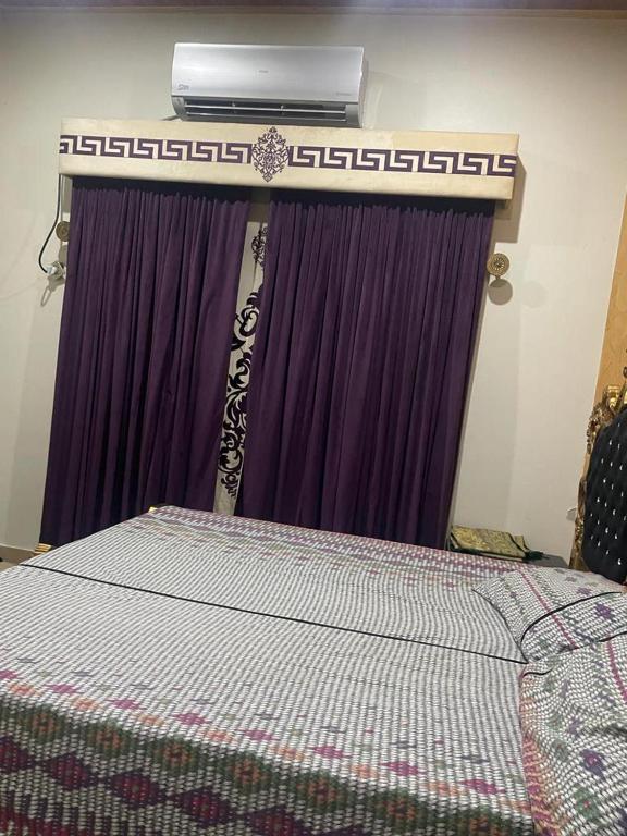 a bedroom with a bed with a air conditioner above it at Warraich villa gt raod gujrat entire in Gujrāt