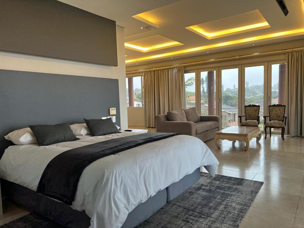 a bedroom with a large bed and a living room at 134 On Ocean View in Amanzimtoti