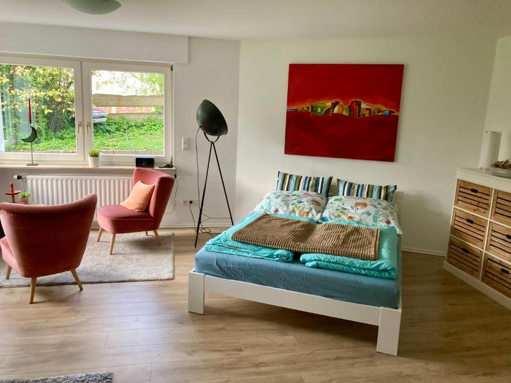 a bedroom with a bed and a desk and a chair at Ferienwohnung Green Village in Menden