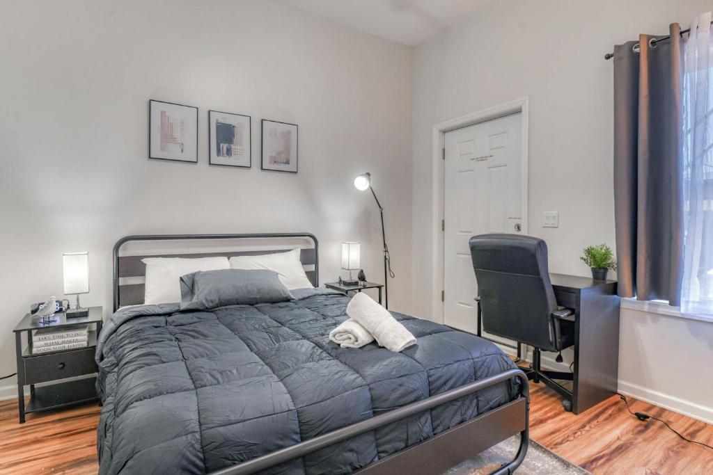 1 dormitorio con cama, escritorio y silla en Gorgeous Duplex with parking by JSQ, en Jersey City