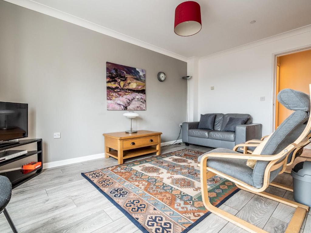 a living room with a couch and a tv at Pass the Keys Central townhouse with parking and modern finish in Exeter