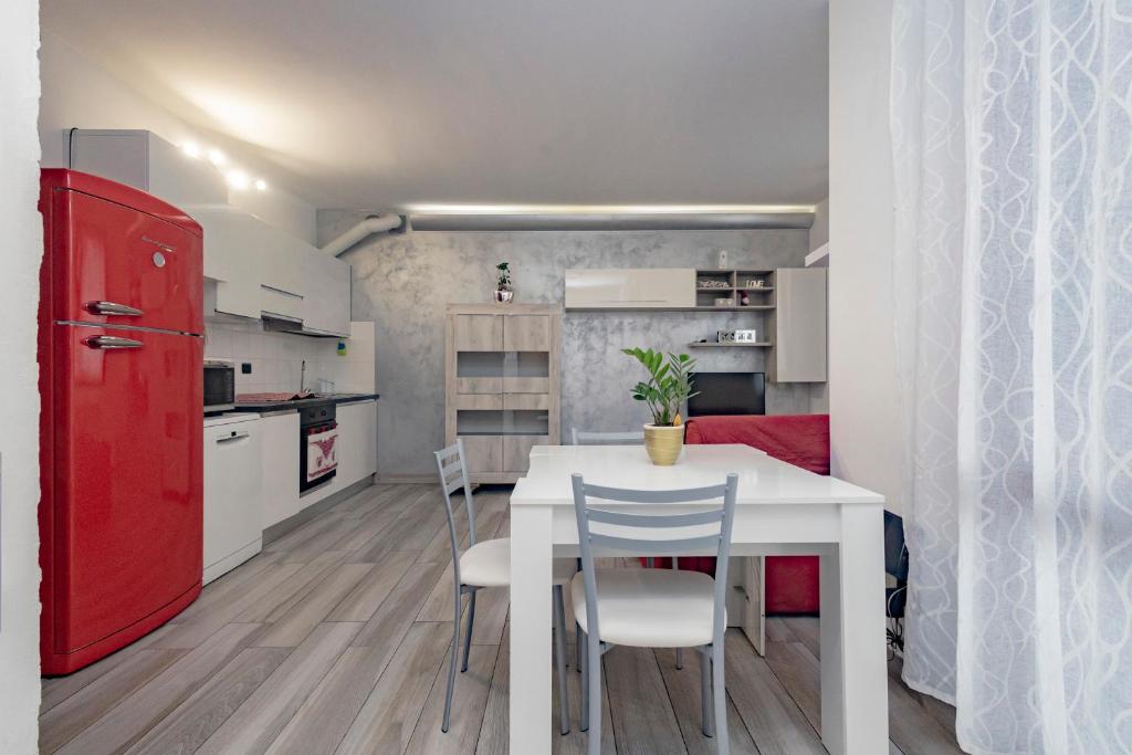 eine Küche mit einem weißen Tisch und einem roten Kühlschrank in der Unterkunft Bomboniera Milano zona RHO FIERA - Bilocale 70mq in Senago