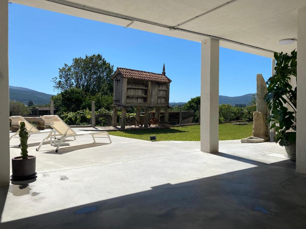 a patio with a chair and a house in the background at CASA do CAMPO in Lestrove