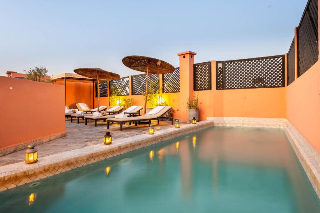 een overloopzwembad met ligstoelen en een resort bij Riad 64 Maison D'hôtes & Spa in Marrakesh