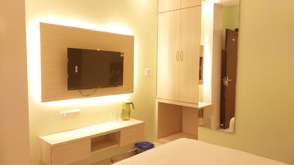 a bedroom with a tv on a wall and a bed at S.S Guest House in Varanasi