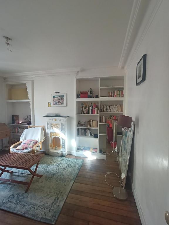 un salon avec une table et une cheminée dans l'établissement Rue du Cambodge, à Paris