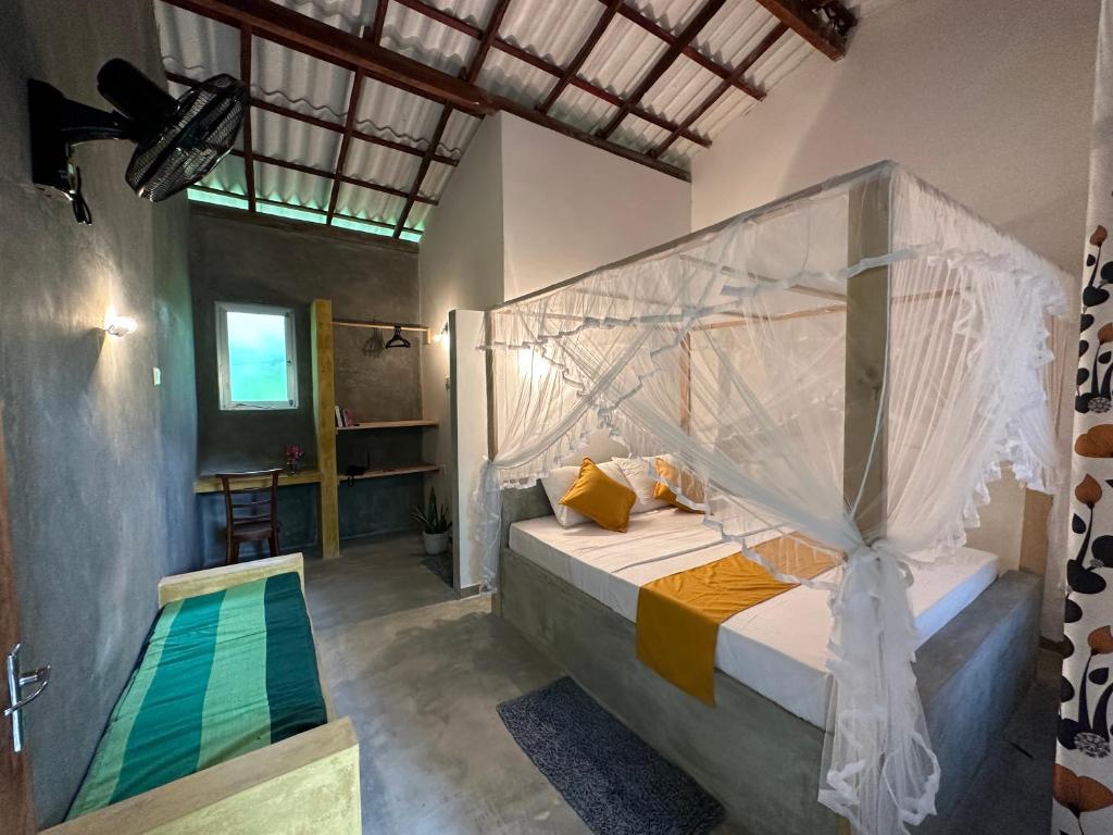 a bedroom with a bed with a mosquito net at Midigama Inn in Ahangama