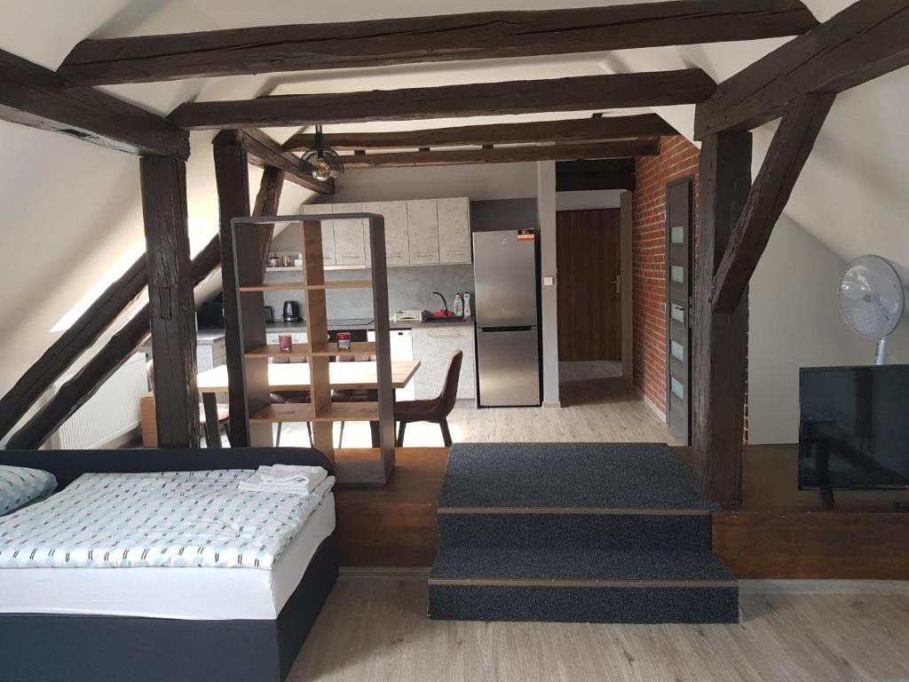 a living room with a bed and a kitchen at Apartmány pod Klášterem in Kladruby