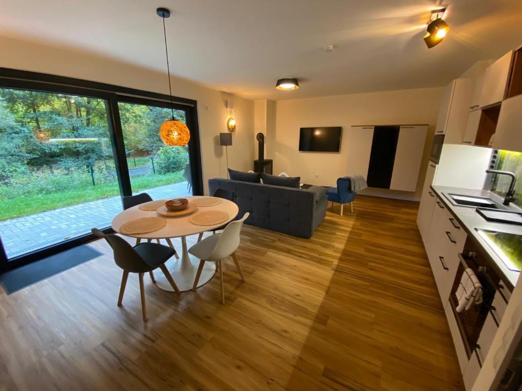 a kitchen and living room with a table and a couch at Luxuriöses rollstuhlgerechtes Ferienapartment A1 mit umzäunten Garten, 65qm in Amtsberg