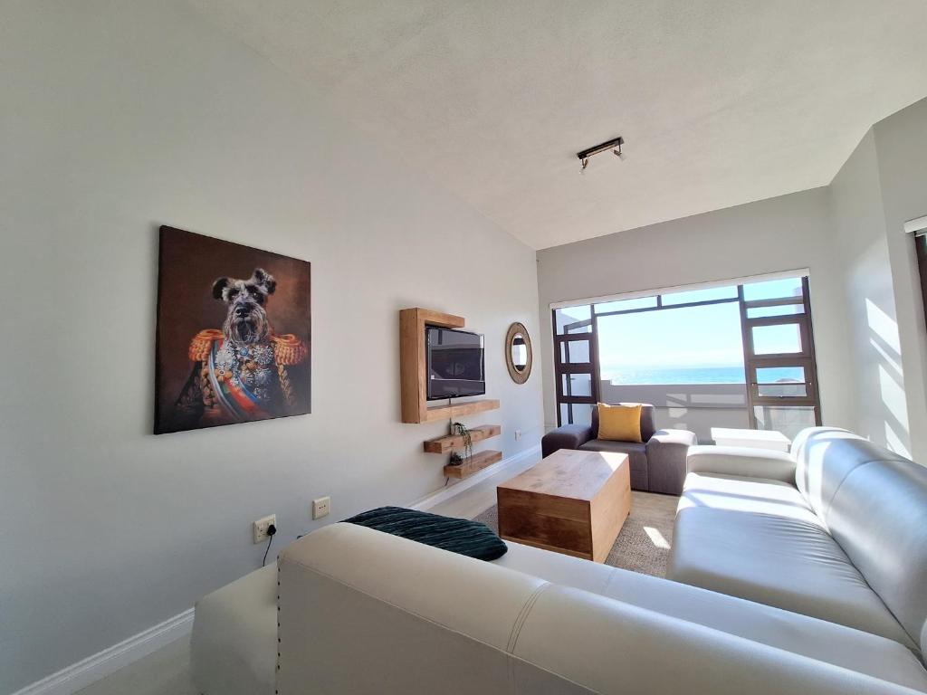 uma sala de estar branca com um sofá e uma televisão em Beyond Beautiful Beach House em Langstrand