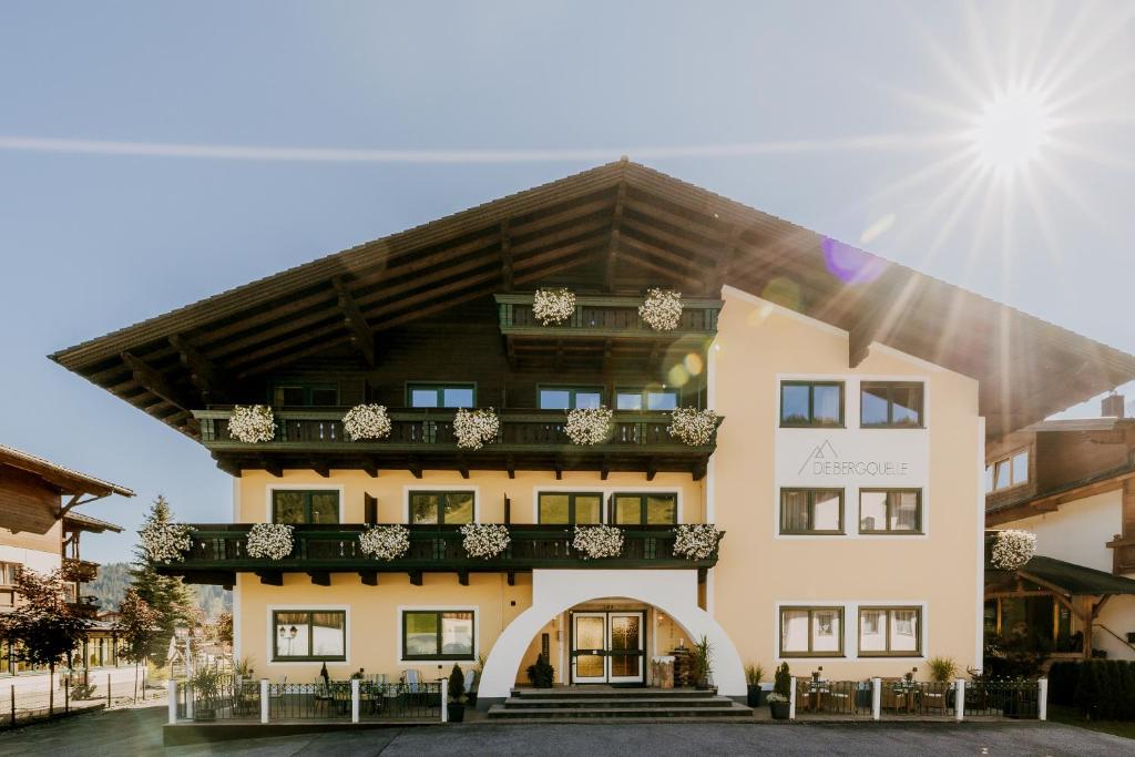 un bâtiment avec un balcon au-dessus dans l'établissement B&B Hotel Die Bergquelle, à Flachau