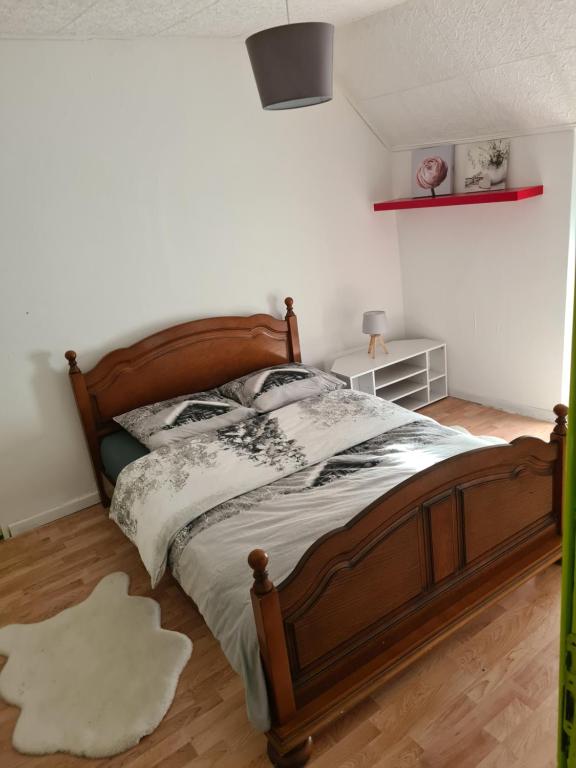 1 dormitorio con cama de madera y suelo de madera en LA REUNION LE LA, 