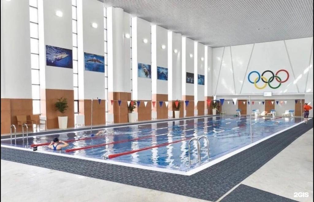 een zwembad waar mensen in zwemmen bij Apartment Korkem 1 at Left Coast in Astana in Astana
