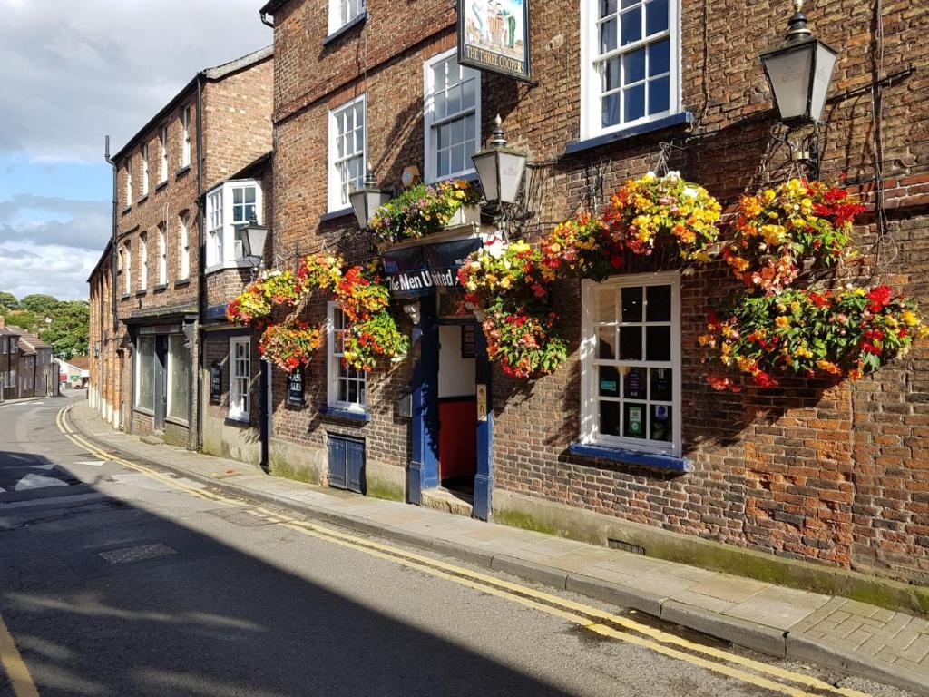 a brick building with flower boxes on the side of it at Three Coopers in Bedale