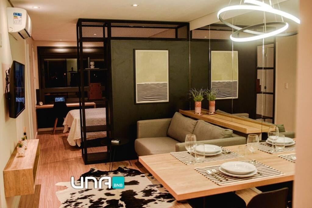 a living room with a couch and a table and a bed at Studio 308 no Parque Una com garagem in Pelotas