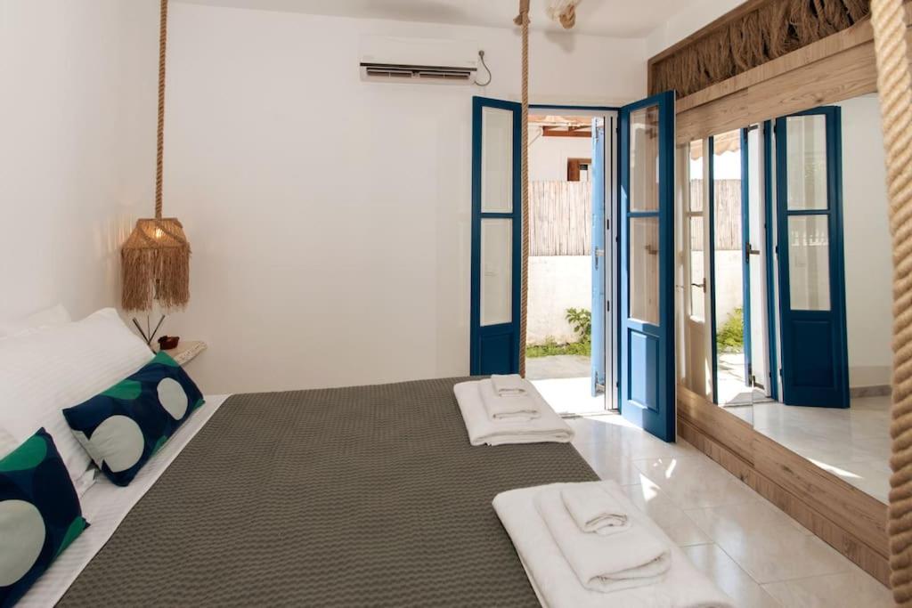 sypialnia z dużym łóżkiem z niebieskimi drzwiami w obiekcie Green Apple w mieście Pollonia