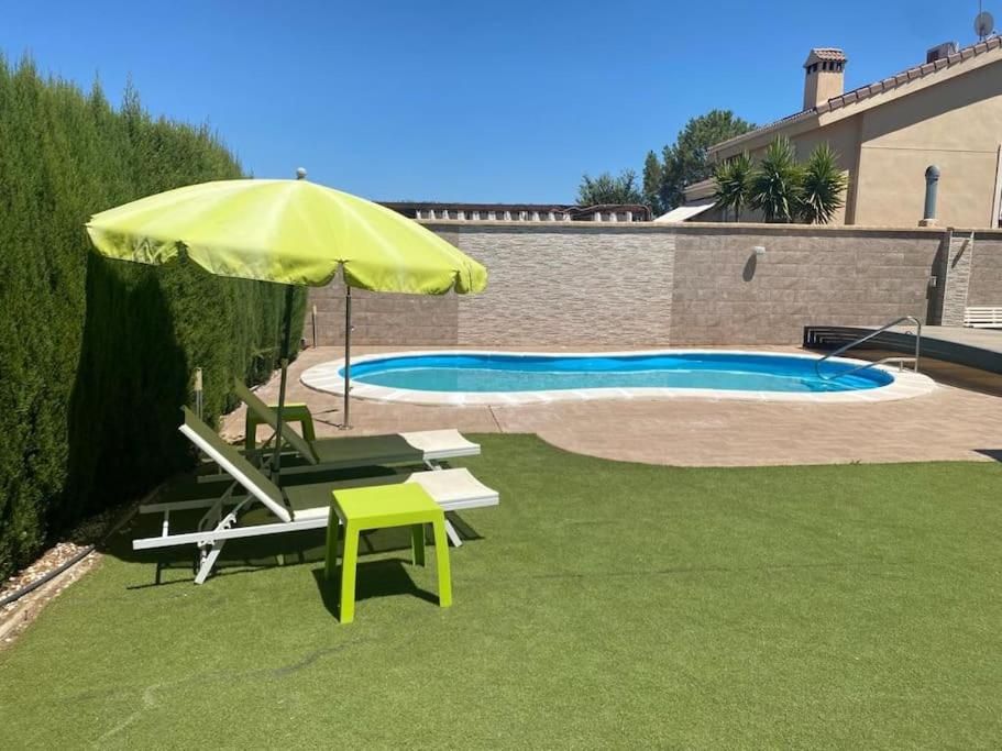 een gele parasol en stoelen en een zwembad bij Casa Aries - Villa con piscina privada in Linares