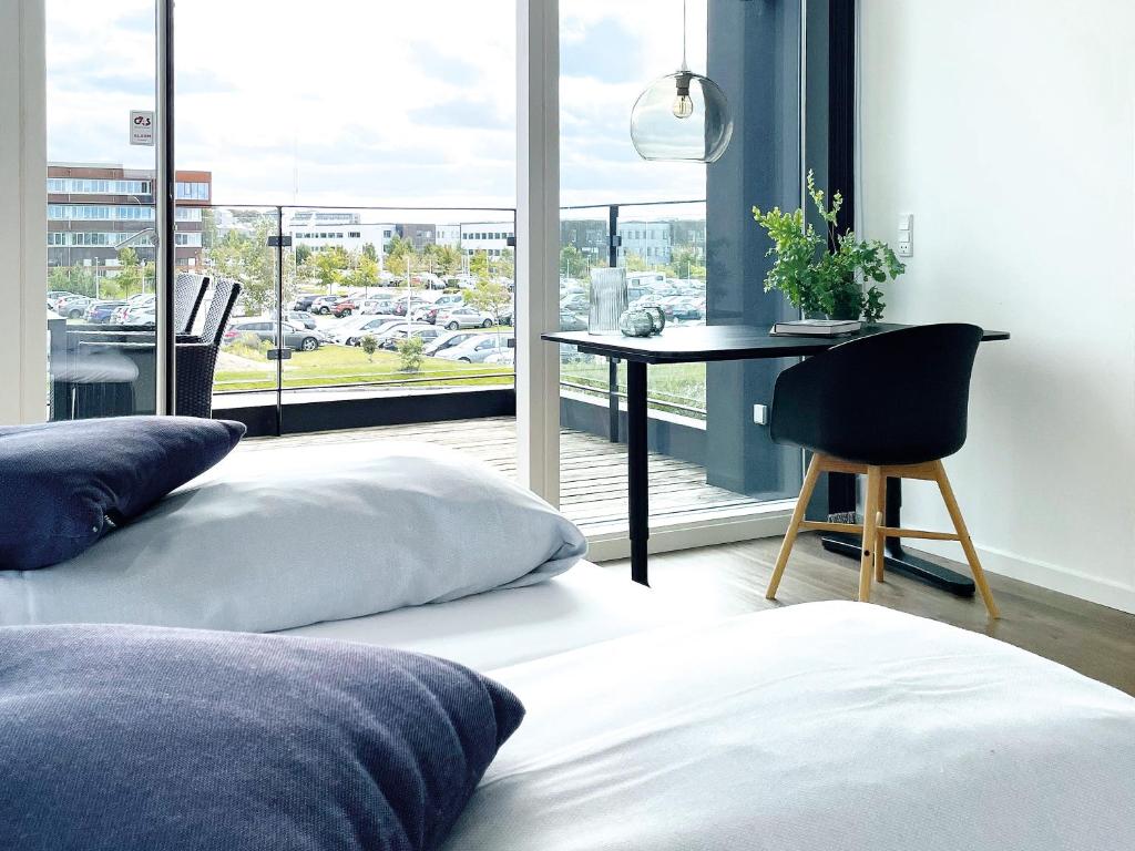 a bedroom with a bed and a table and a window at athome apartments in Aarhus