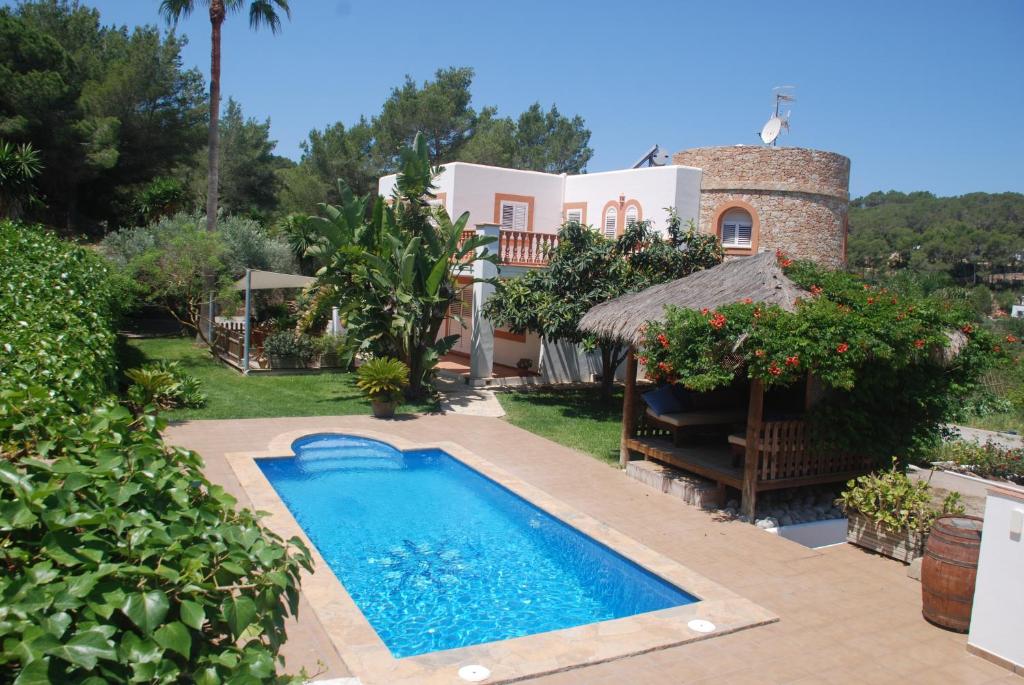 uma villa com piscina em frente a uma casa em Can Pinato em Cala Llonga