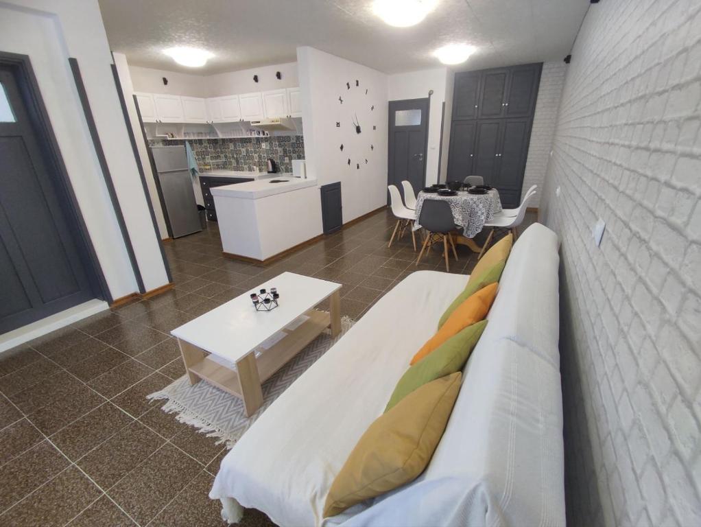 een woonkamer met een bank en een tafel bij Апартамент Фамилия 100м от морето в Равда in Ravda
