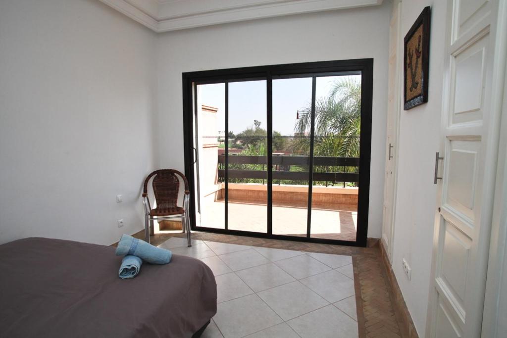 a bedroom with a bed and a sliding glass door at Exceptionnelle Villa duplex 3 ch avec piscine privée dans résidence fermée in Riaïna
