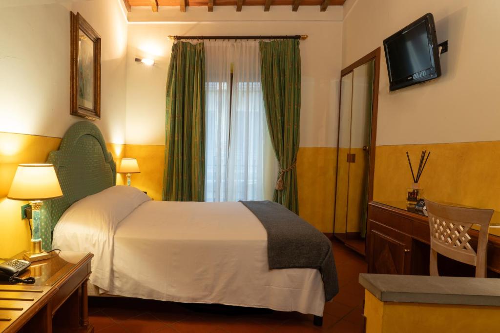 pokój hotelowy z łóżkiem i telewizorem w obiekcie Hotel Panama we Florencji