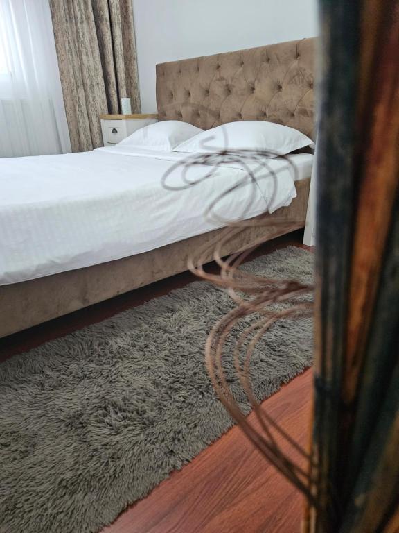 a bedroom with a bed and a rug on the floor at Iosia Premium Apartment in Oradea