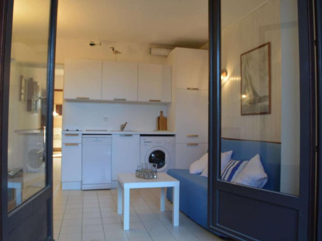 une cuisine avec un canapé bleu et une table dans l'établissement Appartement T2 avec terrasse, piscine, proche plage à Saint-Cyprien - FR-1-225D-26, à Saint Cyprien Plage