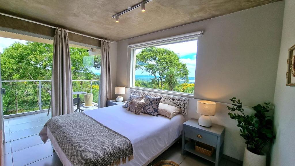 a bedroom with a bed and a large window at Lasuiza Suites in San Bernardino