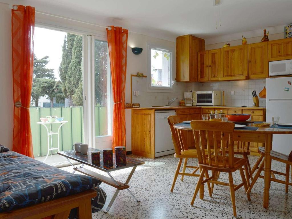 une cuisine avec une table et des chaises ainsi qu'une salle à manger dans l'établissement Appartement Coquet à 100m de la Plage, Quartier Calme, Parking Privatif, Balcon - Argelès-sur-Mer - FR-1-225-670, à Argelès-sur-Mer