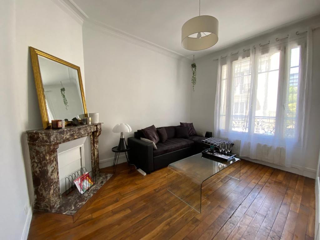 sala de estar con sofá y chimenea en Paris en 10 min, T3 dans le centre ville de Puteaux, en Puteaux