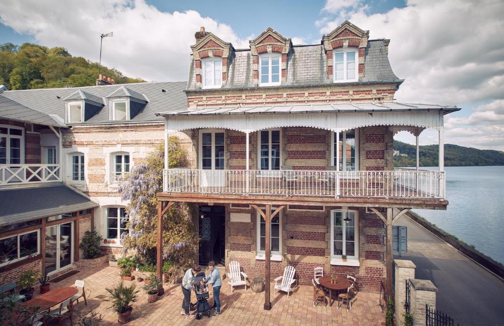 un grupo de personas parados frente a una casa en La Maison Plûme en Villequier