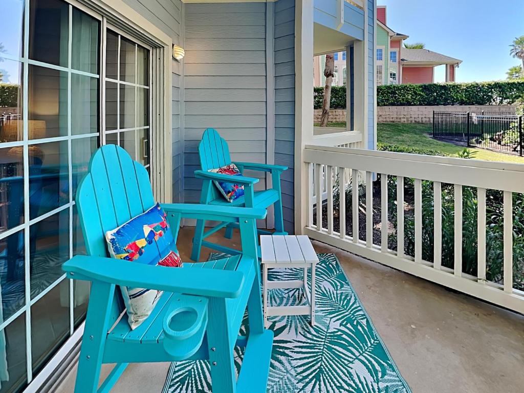 two blue rocking chairs sitting on the front porch of a house at Dawn 315-saltwater Escape in Galveston