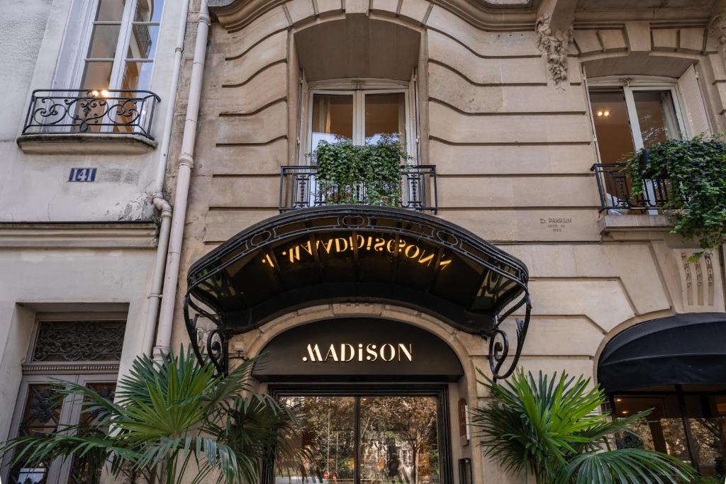 un bâtiment avec un panneau au-dessus de la porte d'un magasin dans l'établissement Hôtel Madison, à Paris