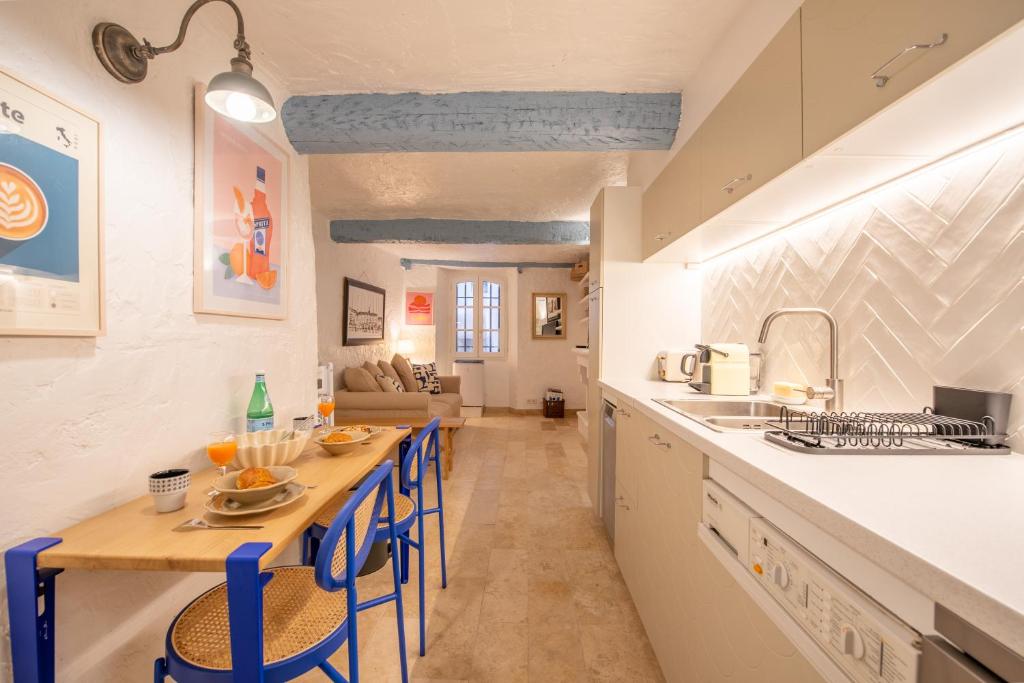 une cuisine et un salon avec une table et des chaises dans l'établissement Appartement vieux village - La Ponche, à Saint-Tropez